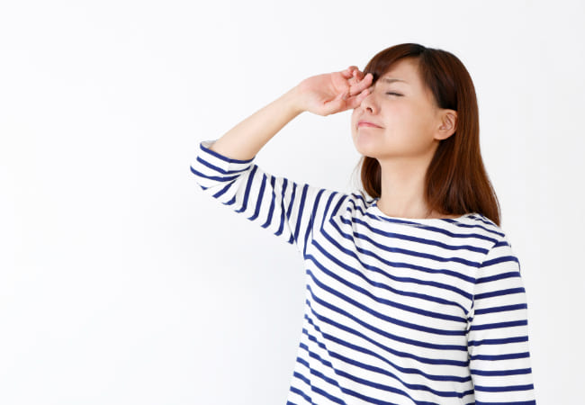 眩しそうにする女性